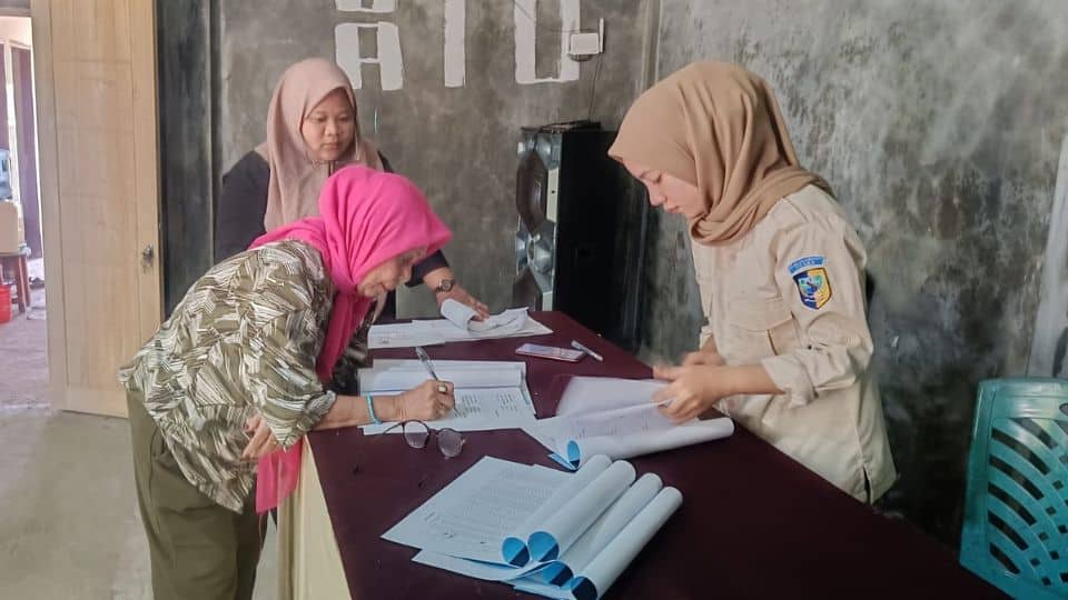 Keluarga Penerima Manfaat (KPM) melakukan penandatanganan berkas administrasi sebagai bukti penerimaan Bantuan Langsung Tunai (BLT) di Kantor Desa Kuala Utara.