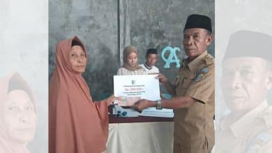 Sangadi Kuala Utara menyerahkan secara simbolis Bantuan Langsung Tunai (BLT) kepada salah satu Keluarga Penerima Manfaat (KPM) periode Januari–April 2026 di Kantor Desa Kuala Utara, Selasa (21/04/2024)